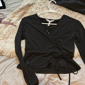 NEW WITH TAGS. NEVER BEEN WORN. Black blouse with tie cross over around waist